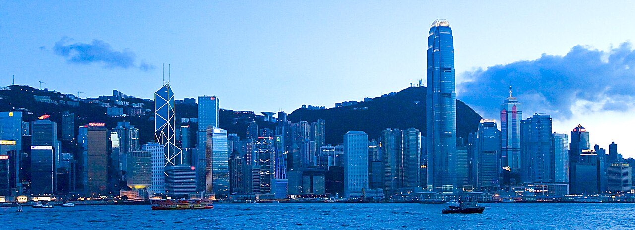 Hong Kong Island skyline at dusk, seen across Victoria Harbour.